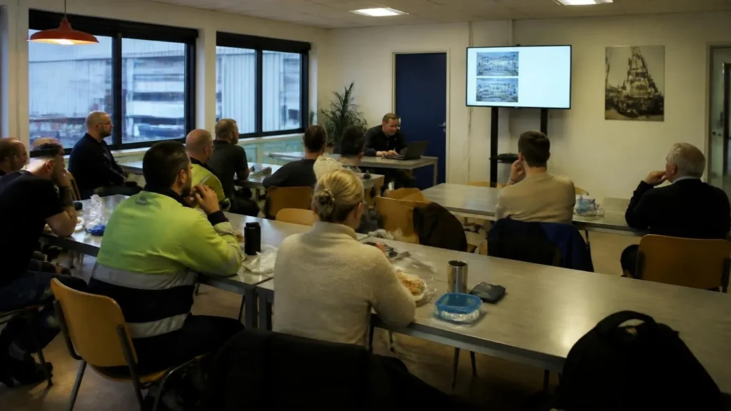 Medewerkers luisteren naar een presentatie in een vergaderzaal